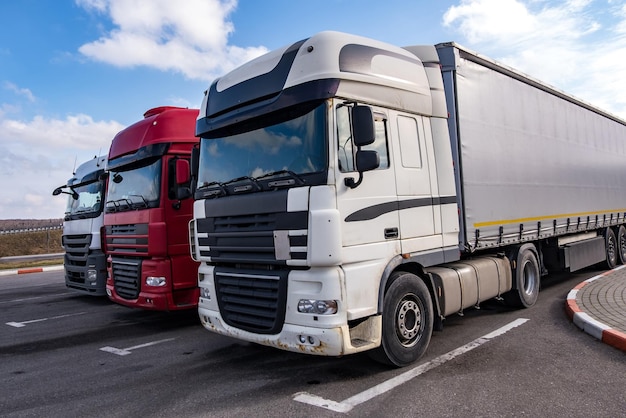 Vrachtwagens op een rij met containers op de parkeerplaats Logistiek en transportconcept