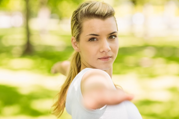 Vreedzaam blonde die yoga in het park doen