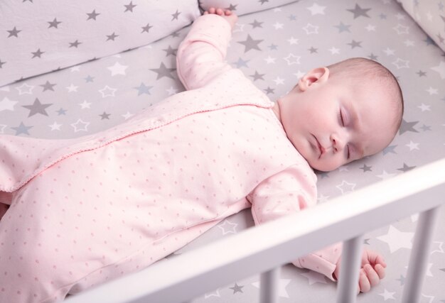 Vreedzame baby liggend op een bed tijdens het slapen, bovenaanzicht