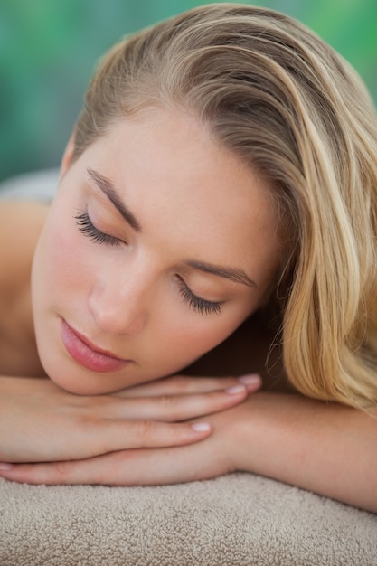 Vreedzame blonde die op handdoek ligt