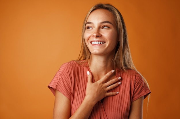 Vreedzame jonge blonde vrouw hand in hand op haar borst.