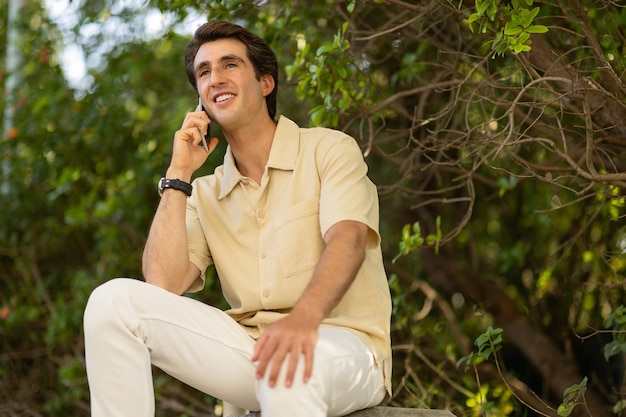 Vreemde knappe millennial man heeft een telefoontje in het park