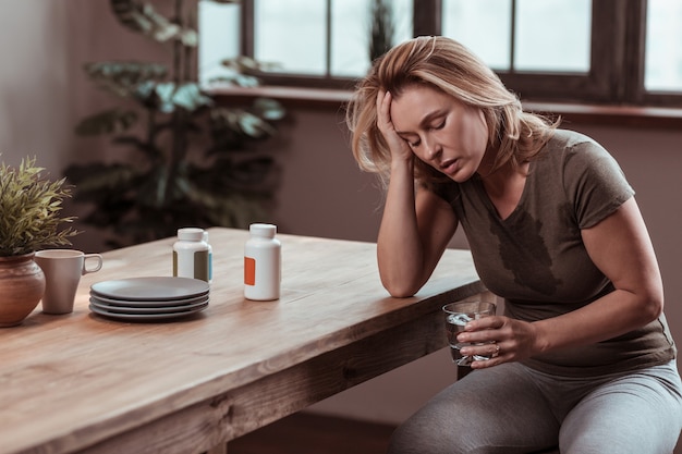 Vreselijk voelen. Gestresste en depressieve vrouw die zweet en zich vreselijk voelt na een paniekaanval