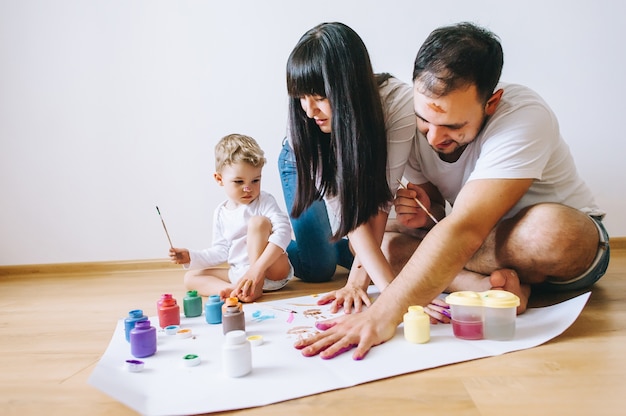 Vreugde familie kunst blij vader moeder en zoon tonen handen in felle kleuren verf samen foto art