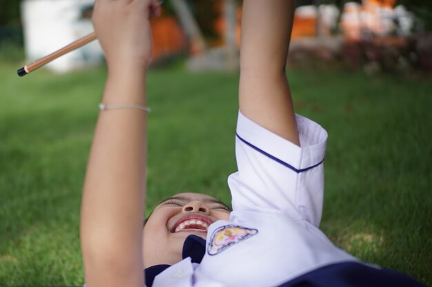 Foto vreugdevol meisje in schooluniform terwijl ze op het veld speelt