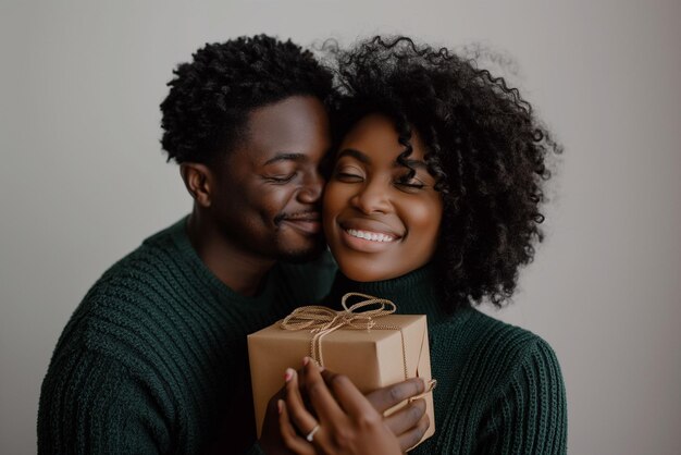 Vreugdevol omhelzen Afro-Amerikaans echtpaar Een hartelijk moment delen met een feestelijk geschenk