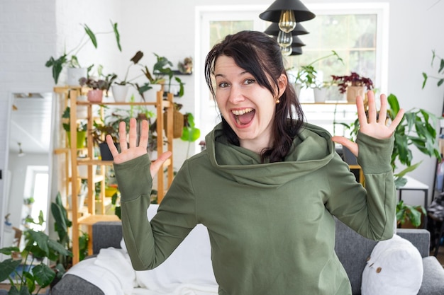 Vreugdevolle emoties van een vrouw in haar huis in een helder modern interieur met huisplanten Ecovriendelijk portret met echte vreugde