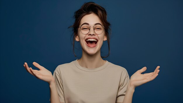 Vreugdevolle jonge vrouw die lacht met opgeheven handen, portret in casual stijl, expressieve gezichtsemoties in een studio, perfect voor lifestyle-concepten.