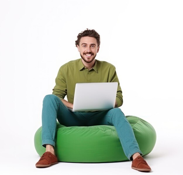 Vreugdevolle man die aan een laptop werkt en op een groene bonenzak zit