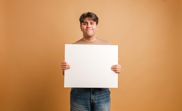 Vreugdevolle man die een lege banier toont in de studio