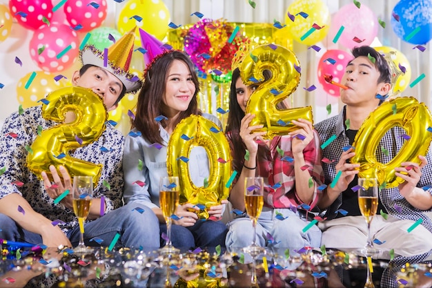 Vreugdevolle mensen ballonnen in de vorm van cijfers 2020