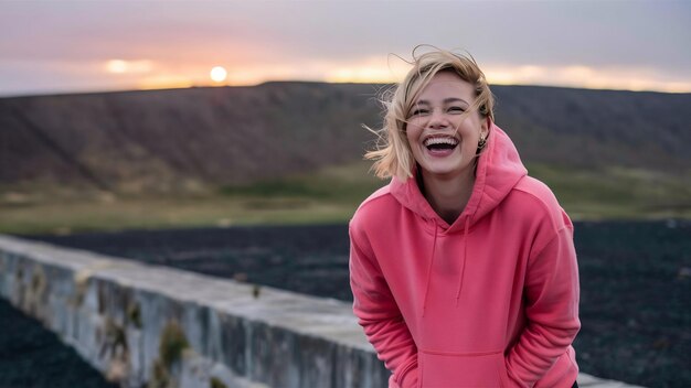 Vreugdevolle vrouw in roze capuchon lacht op een geïsoleerde muur
