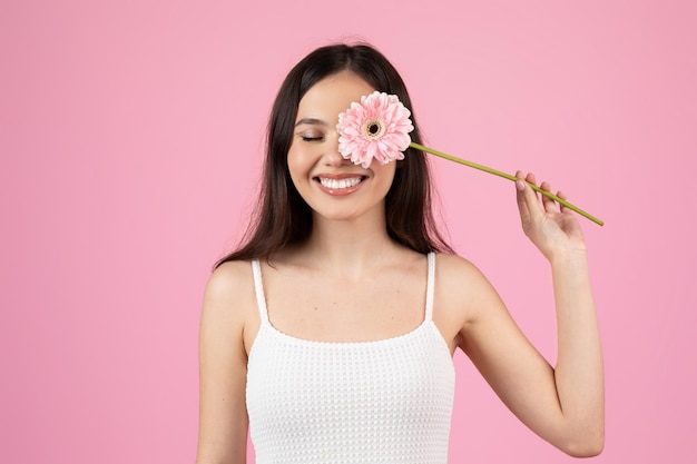 Vreugdevolle vrouw met een roze gerbera bloem