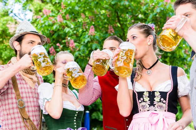 Vriend die zich onder kastanje het roosteren met bier bevindt