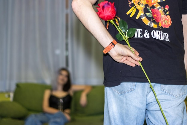 Vriend verbergt een verrassingsroos voor haar vriendje Meisje verbergt een roos voor zijn vriendin op valentijnsdag