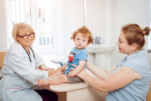 Vriendelijke arts kinderarts met geduldig kind in de kliniek