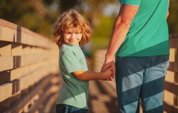 Vriendelijke familie gelukkige vader en zoon zoon strekken handen uit vader knappe man en schattige jongen buiten