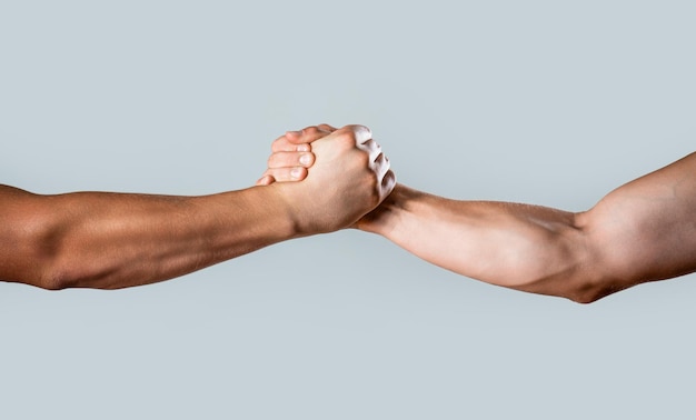 Foto vriendelijke handdruk vrienden groet teamwerk vriendschap twee handen helpende arm van een vriend teamwerk close-up helpende hand uitgestrekte geïsoleerde arm redding close-up help hand