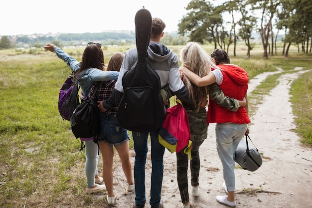 Foto vriendelijke knuffels bewonderen het concept van natuurtoerisme. jeugdreizigersgroep eenheid.