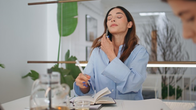 Vriendelijke manager die klant belt in het kantoor Corporate assistent die aantekeningen maakt
