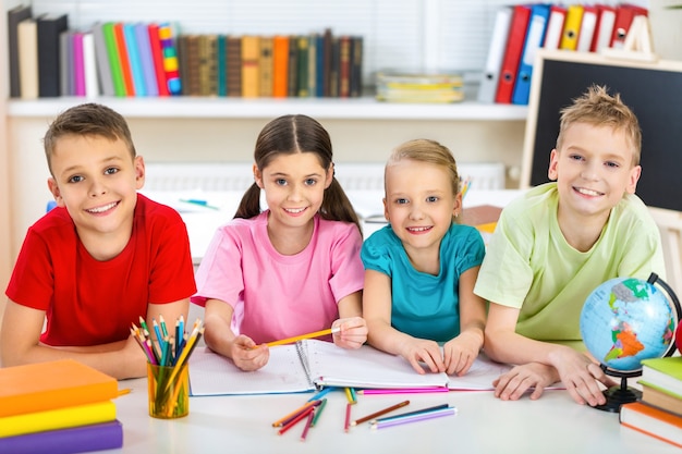 Vriendelijke schoolkinderen met boeken in de klas