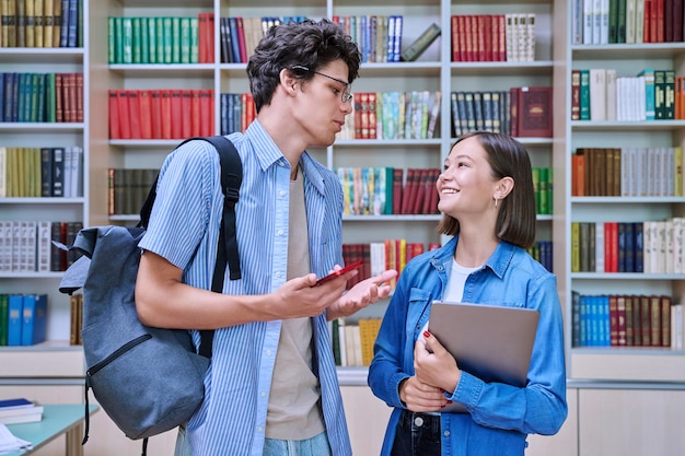 Foto vriendelijke studenten, mannelijk en vrouwelijk, in de bibliotheek.