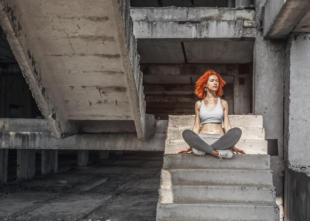 Foto vriendelijke vrouw ontspant zich na een fitness workout in het park op betonnen trappen buiten