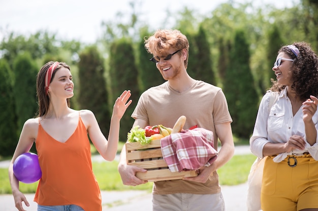 Vrienden, communicatie. vrolijke jonge welvarende mensen die socializen gaan op een warme zonnige dag in het park rusten op een picknick