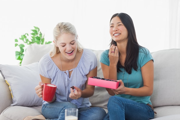 Vrienden delen een doos bonbons en lachen