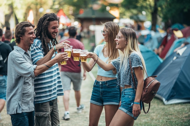 Vrienden die bier drinken en plezier hebben op muziekfestival