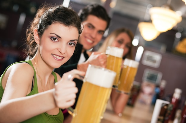 Vrienden die bier in bar drinken