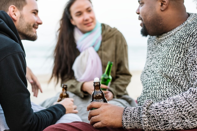 Foto vrienden die bier op het strand drinken