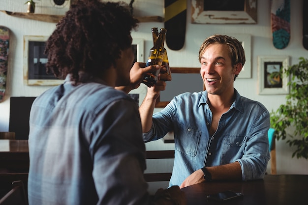 Vrienden die bierflessen roosteren