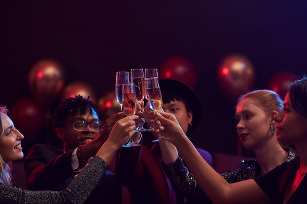 Vrienden die Champagneglazen in Nachtclub opheffen