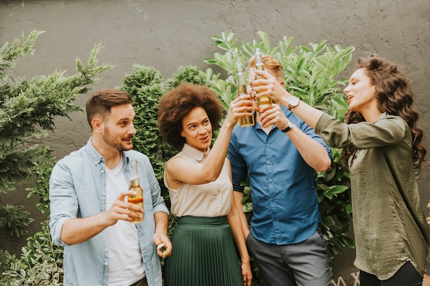 Vrienden die de openluchttoost van de tuinpartij met alcoholische ciderdranken hebben