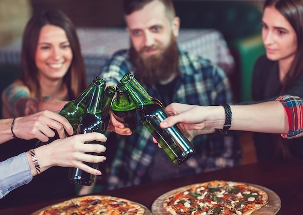 Vrienden die dranken hebben en pizza's in een bar eten