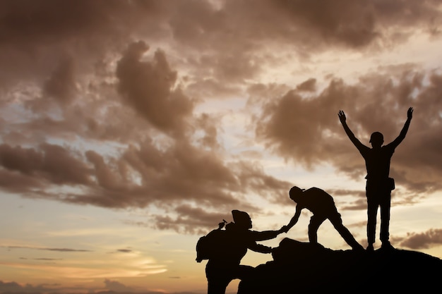 vrienden die elkaar helpen en met teamwerk proberen de top van de bergen te bereiken