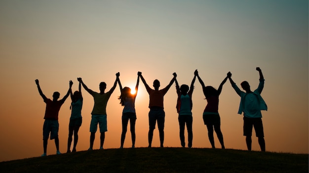 Vrienden die handen houden bij zonsondergang