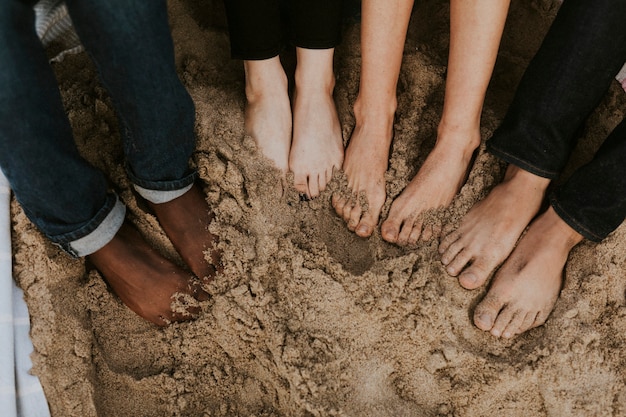 Vrienden die hun voeten in het zand laten weken