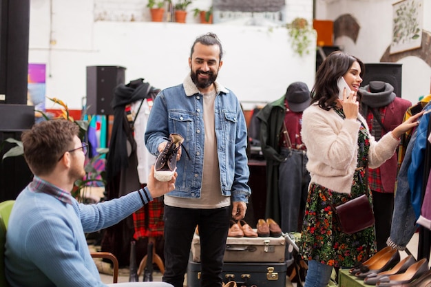 vrienden die kleding kiezen in een vintage kledingwinkel