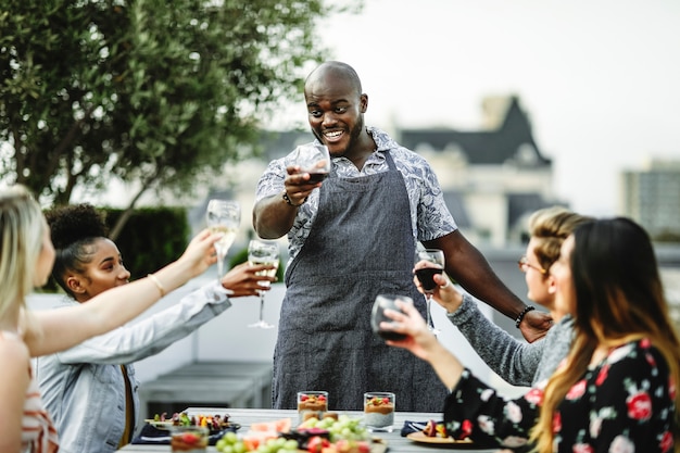 Vrienden die met de chef-kok op een de zomerpartij roosteren