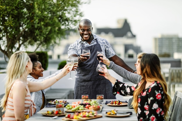 Vrienden die met de chef-kok op een de zomerpartij roosteren