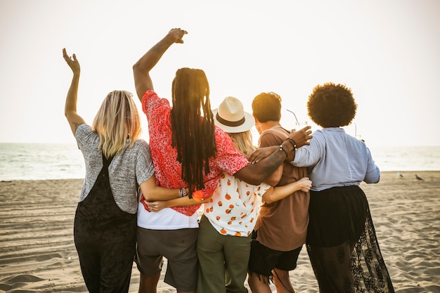 Vrienden die op de zonsondergang op het strand letten