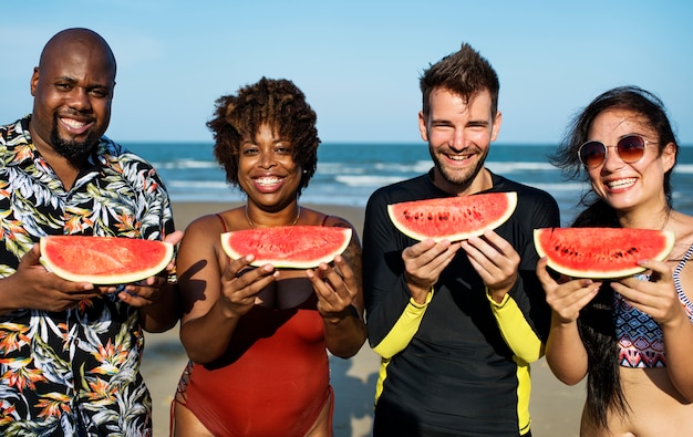 Vrienden die watermeloen op het strand eten