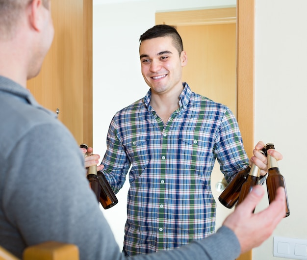 Vrienden die zich thuis verzamelen om bier te drinken