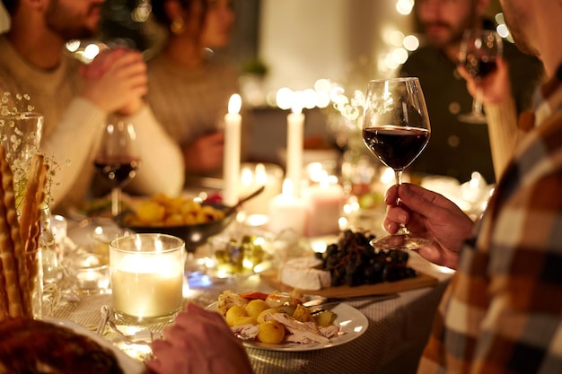 Vrienden drinken rode wijn op een kerstfeest.
