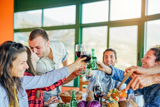 Foto vrienden drinken terwijl ze tegen het raam thuis zitten.