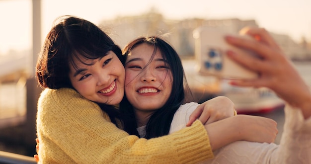 Vrienden en knuffels met selfie Japanse influencer team buiten met herinnering en sociale media post Geluk vriendschap date in Kyoto met reizen en glimlachen in foto fotografie en avontuur