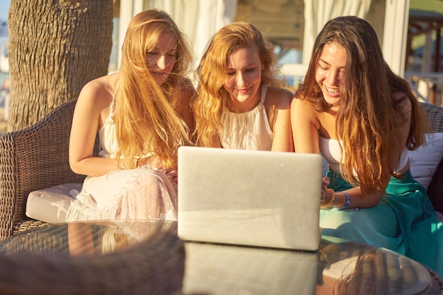 Foto vrienden gebruiken een laptop in de stad op een zonnige dag.