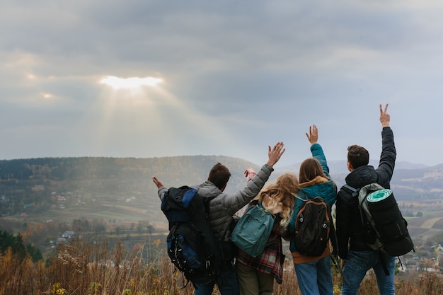 Vrienden genieten van de zonnestralen die door de wolken in de bergen schijnen